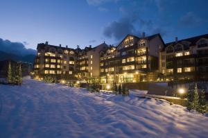 a row of buildings in the snow at night at Premier Luxury Mountain Resort in Bansko