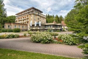 ein großes Gebäude mit weißen Blumen davor in der Unterkunft Sure Hotel by Best Western Bad Dürrheim in Bad Dürrheim