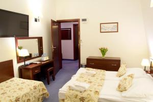 a hotel room with two beds and a mirror at Hotel Patria Zakopane Centrum in Zakopane