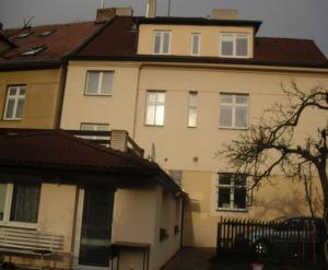 een groot wit huis met een bruin dak bij Pension Hanspaulka in Praag