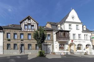 un grande edificio bianco con un albero di fronte di Apartmenthaus Burgenheimat in Rhens bei Koblenz a Rhens