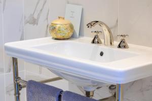 ein weißes Waschbecken im Bad mit einer Vase darauf in der Unterkunft The Studio at Maspie House in Falkland