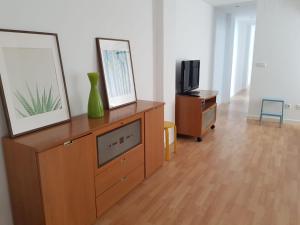 sala de estar con TV y tocador de madera en FLORIT FLATS - The Jardines del Turia Apartment en Valencia