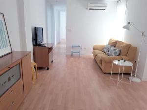 ein Wohnzimmer mit einem Sofa und einem TV in der Unterkunft FLORIT FLATS - The Jardines del Turia Apartment in Valencia