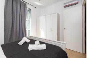 バルセロナにあるLovely and Convenient Sagrada Familia Apartmentのベッドルーム1室(大きな鏡付きのベッド1台、タオル2枚付)