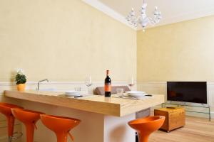 una cocina con una barra con sillas naranjas y una botella de vino en Stella Polare - Luxury apartment, en Lucca
