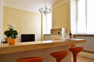 eine Küche mit einer Theke und orangefarbenen Stühlen in der Unterkunft Stella Polare - Luxury apartment in Lucca