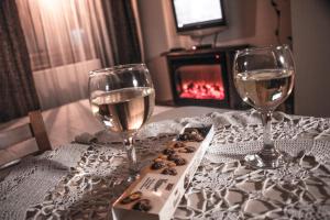 a table with two glasses of wine and a box of cookies at Bansko home with a Mountain view in Bansko
