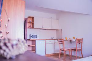 a kitchen with white cabinets and a table and chairs at Bansko home with a Mountain view in Bansko