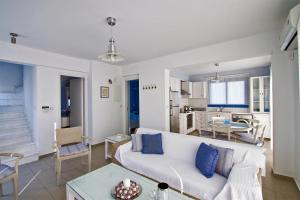 a living room with a white couch and a table at Meltemi Villas in Paphos City