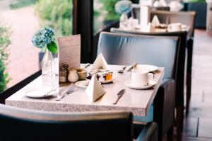 a table with plates of food and a vase of flowers at Abbey House Hotel in Barrow in Furness