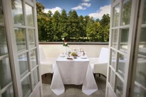 a table with a white table cloth and flowers on a balcony at Dwór Many, blisko do Suntago & DeepSpot in Many