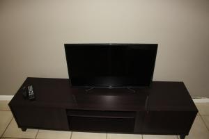 a flat screen tv sitting on top of a black table at Kusha Two in Sabie