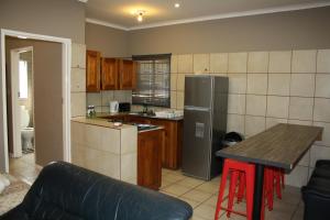 a kitchen with a refrigerator and a table in it at Kusha Two in Sabie