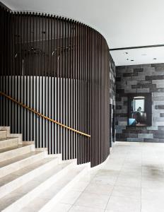 a lobby with stairs and a wall with wood at AMERON Hamburg Hotel Speicherstadt in Hamburg