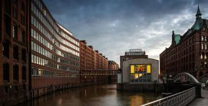 a city with a river with buildings and a bridge at AMERON Hamburg Hotel Speicherstadt in Hamburg