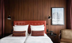 a hotel room with a bed with a red headboard at AMERON Hamburg Hotel Speicherstadt in Hamburg