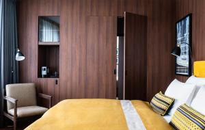 a bedroom with a bed and a chair and a window at AMERON Hamburg Hotel Speicherstadt in Hamburg