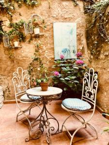 two chairs and a table in a room with flowers at Casa Rural Mirador in Bocairent