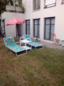 ルガノにあるCasa Danyの庭に芝生の椅子2脚と傘