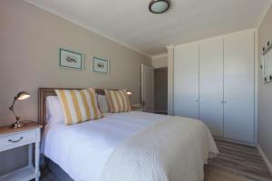 a bedroom with a white bed and a white cabinet at position, Position, POS-ITION! Adjacent CB Beach in Cape Town