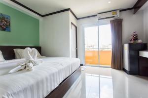 a bedroom with a bed with a bow on it at Kulasub Hotel in Hat Yai