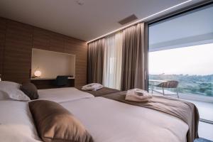 诺瓦利娅Aparthotel Joel的酒店房间里有两张床，窗户很大