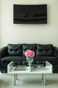 a black couch with a vase with a pink rose on a table at Kulasub Hotel in Hat Yai +8 photos