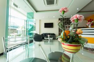 a vase with flowers on a table in a room at Kulasub Hotel in Hat Yai