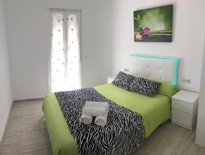 バレンシアにあるBella Vistaのベッドルーム1室(緑のベッド1台、シマウマのプリントシーツ付)
