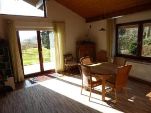 comedor con mesa, sillas y ventana en Ferienhaus Torsholt, en Westerstede