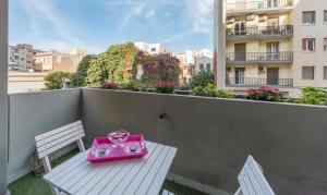 カリアリにあるGreen Apartment-City Centreのピンクのトイカムプーター(バルコニーのテーブルに座る)