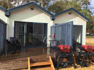 a deck with chairs and a table in front of a house at Coonawarra Ensuite Unit B in Coonawarra