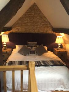 a bedroom with a large bed with two lamps at The Radnor Arms in Malmesbury