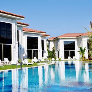 a swimming pool in front of a house at Paloma Oceana - Luxury Hotel in Side