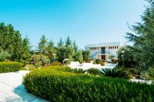 a garden in front of a building at Giardino Degli Ulivi Resort Masseria in Margherita di Savoia