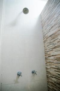 una ducha con dos perillas en la pared en EH Ejecutivo Urban, en Tepic