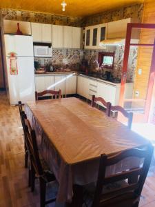a kitchen with a large wooden table and chairs at Casa de Campo Vale Rio dos Bugres in Urubici