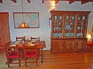 uma sala de jantar com uma mesa e cadeiras e um armário de louça em The Old School em Ballyheigue