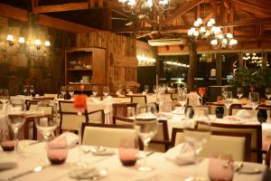 un comedor con mesas y sillas blancas en Iguazu Jungle Lodge en Puerto Iguazú