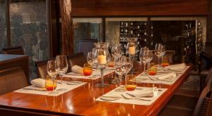 a long table in a restaurant with wine glasses at Iguazu Jungle Lodge in Puerto Iguazú