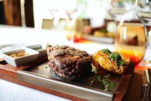 a steak and potatoes on a plate on a table at Iguazu Jungle Lodge in Puerto Iguazú