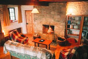 a living room with a fireplace and a couch and a table at The Old School in Ballyheigue