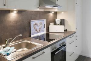 a kitchen with a sink and a counter top at Haus Meeresblick FeWo Duenenwind 0 in Baabe