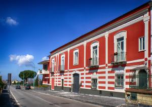 un edificio rojo y blanco al lado de una calle en Bed and Breakfast Sommavesuvio, en Pollena Trocchia