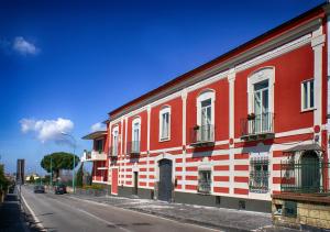 a red and white building on the side of a street at Bed and Breakfast Sommavesuvio in Pollena Trocchia