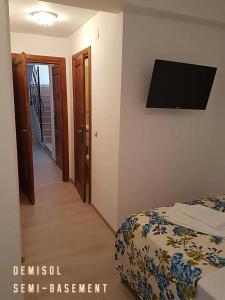 a bedroom with a bed and a flat screen tv at Pensiunea Geostar in Curtea de Argeş