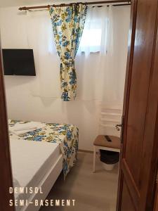 a small bedroom with a bed and a window at Pensiunea Geostar in Curtea de Argeş