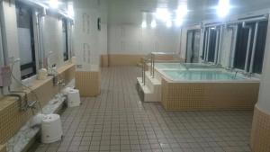 a large bathroom with a tub and sinks and mirrors at A-GATE Hotel Hakodate in Hakodate