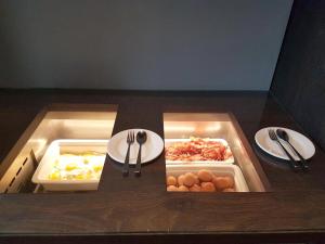 a lunch box with food and utensils on a table at Fletcher Boutique Hotel Duinoord in Wassenaar